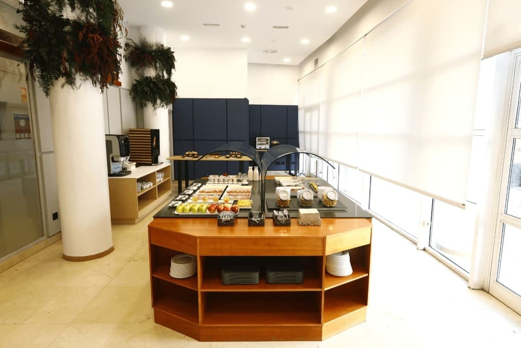 Restaurante del hotel Travelodge en Barcelona con mesas elegantes y platos de cocina mediterránea